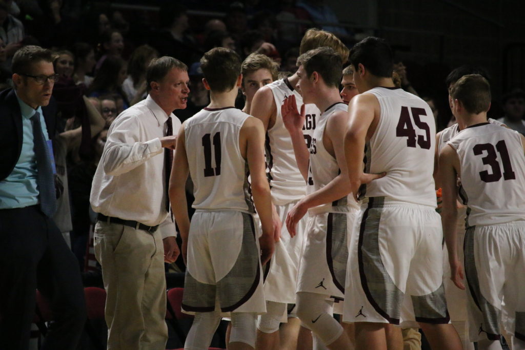 Coach Dwayne Carter counsels his team in the fourth quarter. Photo by Anne Berleant